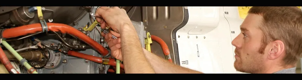 Image of man working on helicopter engine